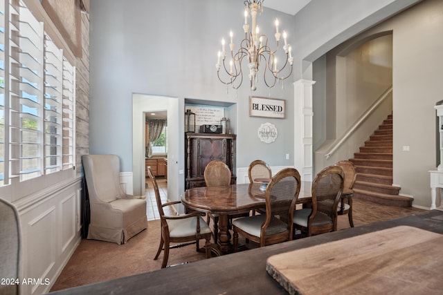 dining room featuring carpet flooring, a high ceiling, a healthy amount of sunlight, and stairway