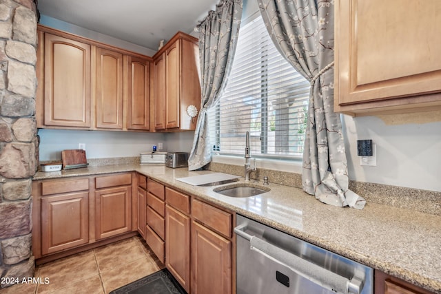 kitchen featuring light tile patterned floors, light stone counters, a sink, and dishwasher