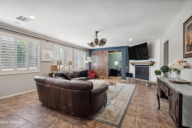 living area with visible vents, tile patterned flooring, a fireplace, a notable chandelier, and ornamental molding