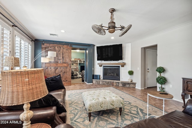 living room with a ceiling fan, visible vents, a large fireplace, baseboards, and ornamental molding
