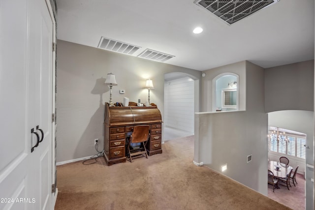 office featuring carpet flooring, arched walkways, visible vents, and a chandelier