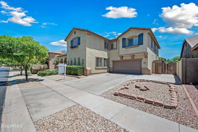 view of front facade featuring a garage, fence, stucco siding, a gate, and driveway