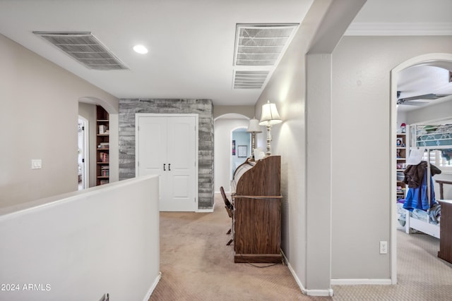 corridor featuring arched walkways, baseboards, carpet, and visible vents