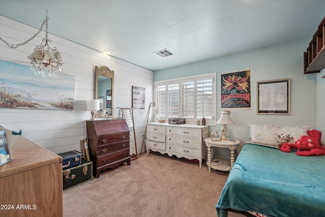 bedroom featuring wooden walls, light colored carpet, and visible vents