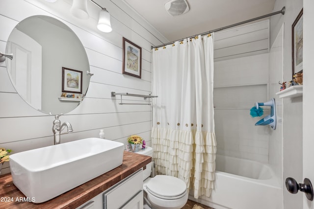 full bathroom featuring toilet, shower / bath combo with shower curtain, and vanity