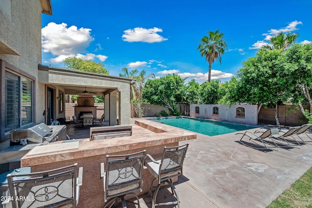 view of pool with exterior kitchen, a patio area, a bar, a fenced in pool, and a fenced backyard