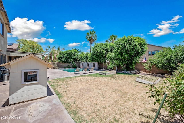 view of yard featuring a patio, a fenced in pool, a fenced backyard, and a vegetable garden