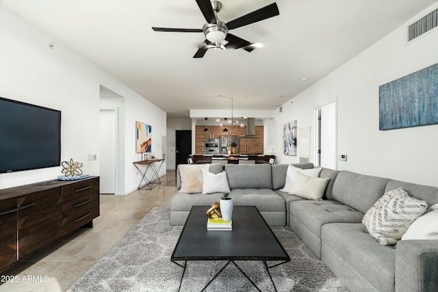 living room with ceiling fan with notable chandelier