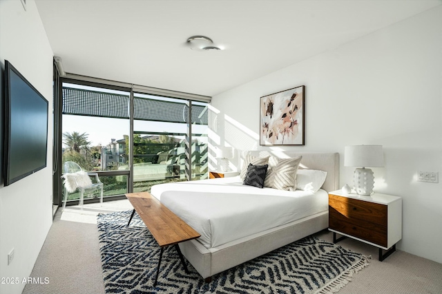 bedroom featuring light carpet and expansive windows