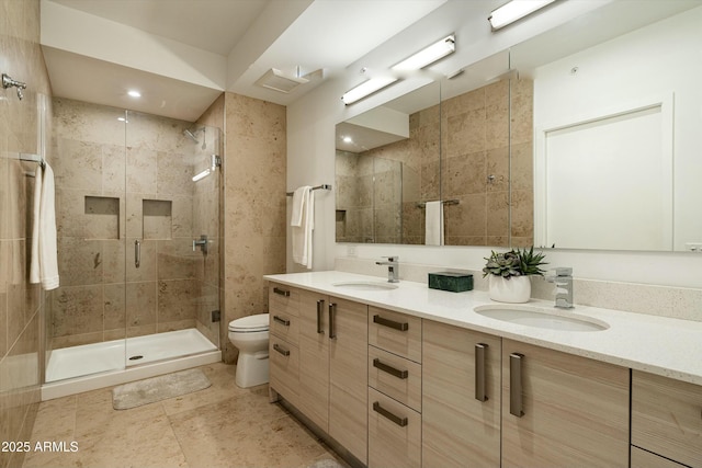 bathroom with toilet, a shower with shower door, and vanity