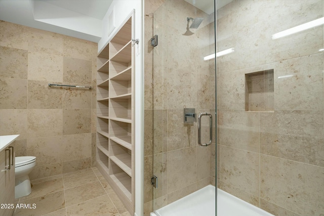 bathroom with toilet, a shower with shower door, and vanity