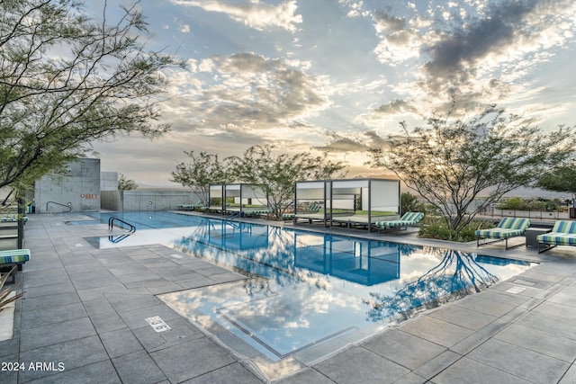 pool at dusk featuring a patio area