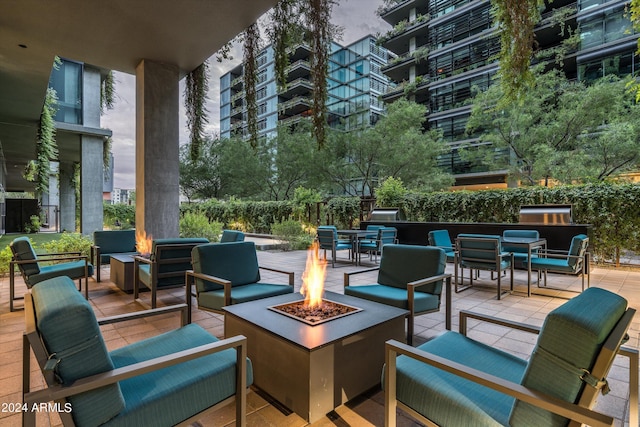 view of patio with an outdoor living space with a fire pit