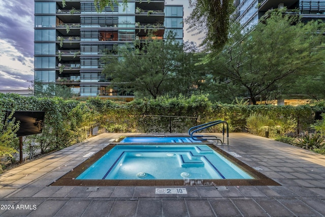 view of swimming pool with a hot tub