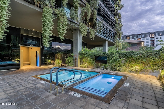 view of pool with a hot tub and a patio area