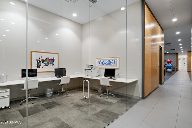 tiled office space with built in desk and a high ceiling