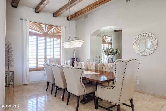 dining room with beam ceiling and a notable chandelier