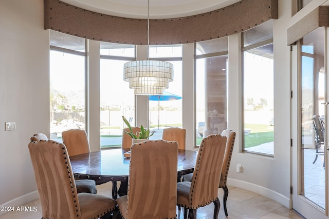 tiled dining area featuring a notable chandelier and a healthy amount of sunlight