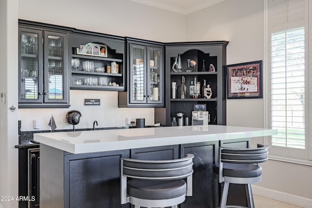 bar with crown molding, light tile patterned floors, decorative backsplash, and a healthy amount of sunlight