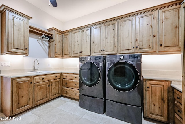 washroom with cabinets, light tile patterned flooring, sink, washing machine and clothes dryer, and ceiling fan