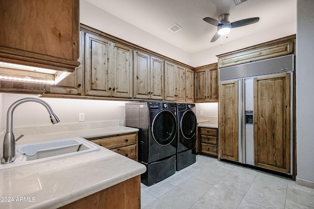 laundry area with washer and clothes dryer, sink, ceiling fan, and cabinets