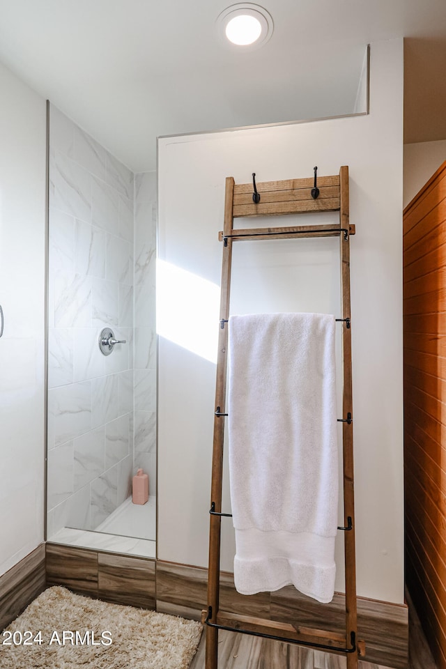 bathroom featuring hardwood / wood-style flooring and tiled shower