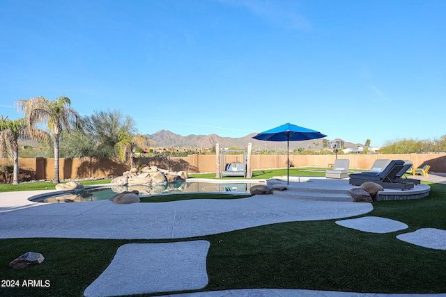 exterior space featuring a patio, a mountain view, and a fenced in pool