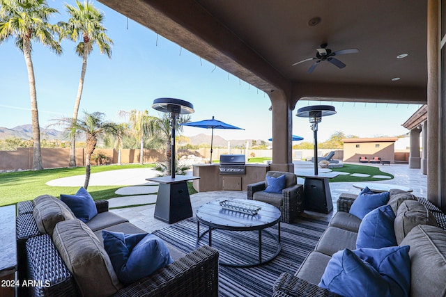 view of patio featuring exterior kitchen, ceiling fan, outdoor lounge area, and grilling area