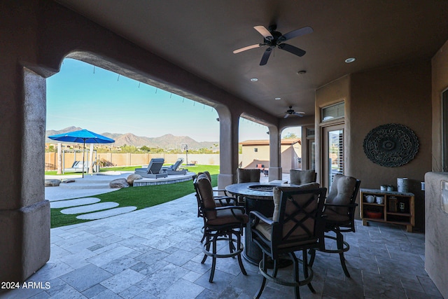 view of patio / terrace with ceiling fan and a mountain view