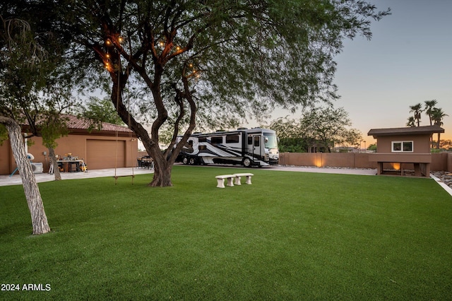 yard at dusk featuring a garage