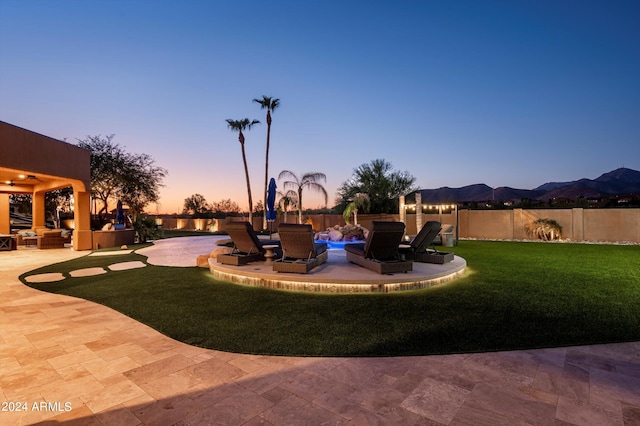 yard at dusk featuring a patio and a jacuzzi