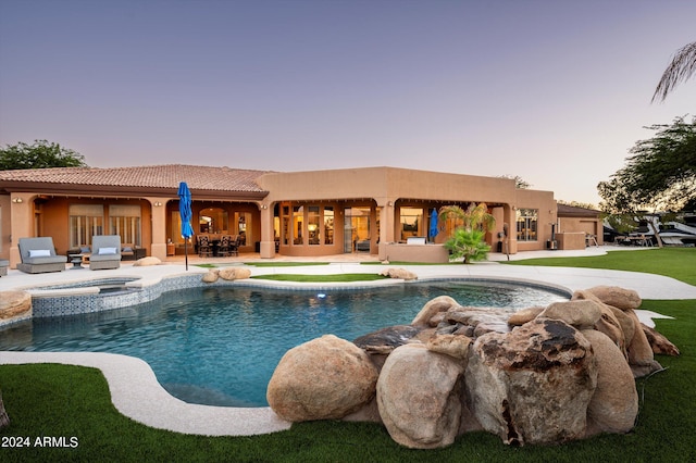 pool at dusk featuring a patio and outdoor lounge area