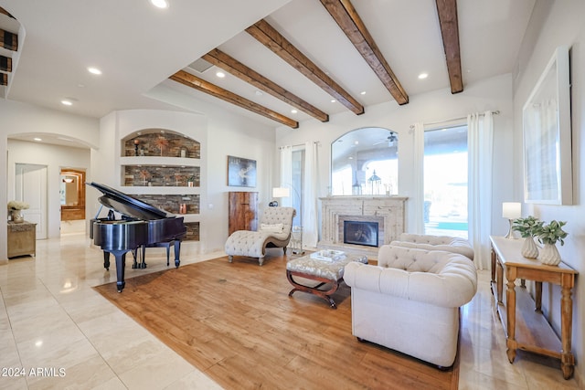 living room with light hardwood / wood-style flooring, beam ceiling, and a high end fireplace