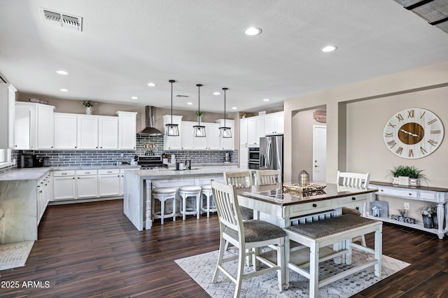 21328 E Misty Ln, Queen Creek, AZ 85142 - kitchen featuring light countertops, wall chimney range hood, backsplash, and visible vents