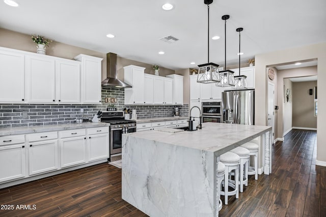 21328 E Misty Ln, Queen Creek, AZ 85142 - kitchen with dark wood-style flooring, wall chimney range hood, visible vents, and stainless steel appliances