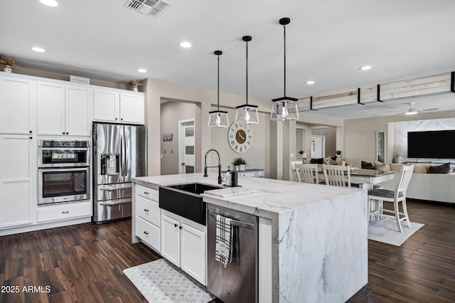 21328 E Misty Ln, Queen Creek, AZ 85142 - kitchen featuring visible vents, a sink, a kitchen island with sink, stainless steel appliances, and light stone counters