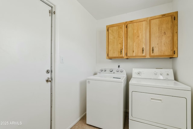 washroom with cabinet space, washer and clothes dryer, and light tile patterned flooring