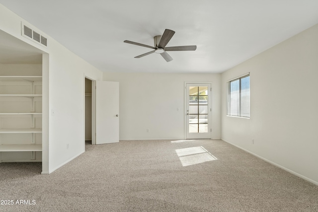 empty room featuring ceiling fan, baseboards, visible vents, and carpet floors