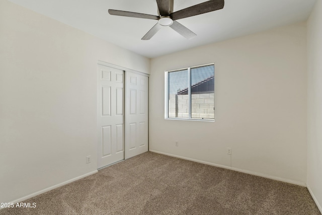 unfurnished bedroom featuring a closet, baseboards, a ceiling fan, and carpet