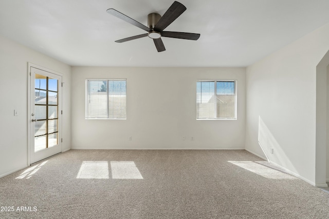 spare room featuring baseboards, a ceiling fan, and light colored carpet