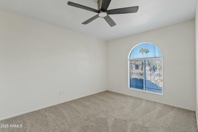 unfurnished room with baseboards, a ceiling fan, and carpet
