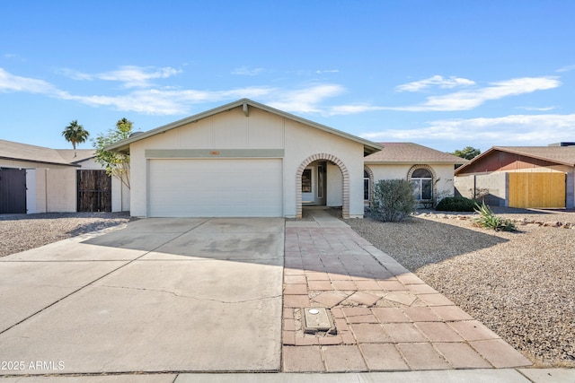 ranch-style house with driveway, fence, and an attached garage