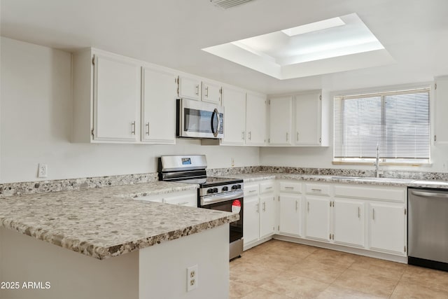 kitchen with stainless steel appliances, light countertops, a sink, and white cabinetry