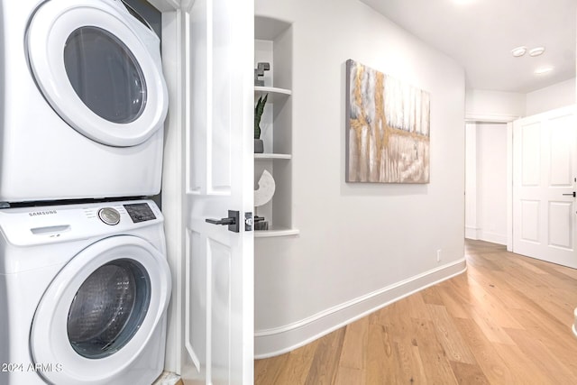 washroom with light wood-type flooring and stacked washer / drying machine