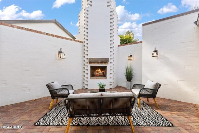 view of patio / terrace with an outdoor living space with a fireplace