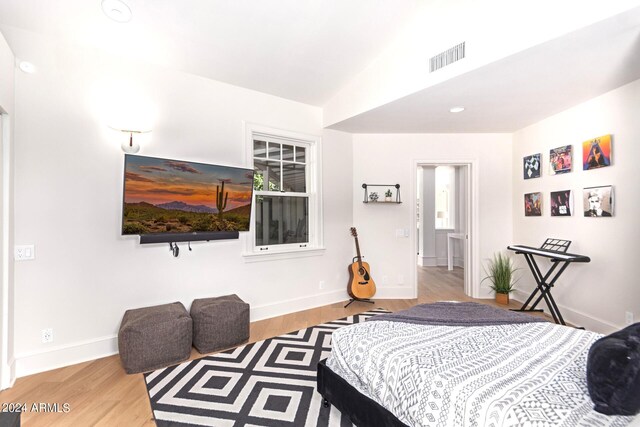 bedroom featuring light wood-type flooring and lofted ceiling