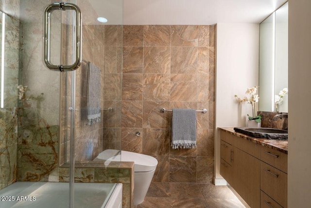 bathroom with vanity, tile walls, toilet, and walk in shower