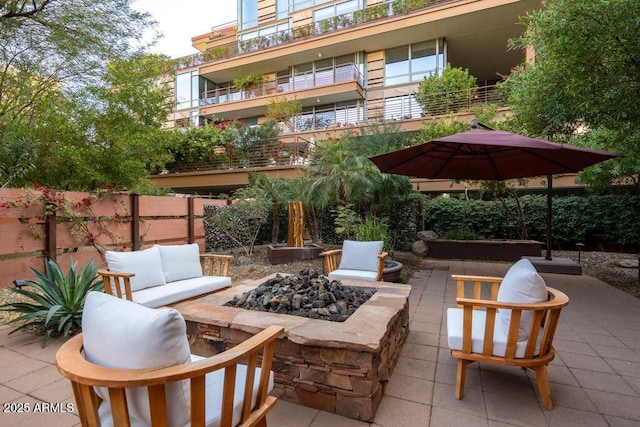 view of patio with an outdoor living space with a fire pit