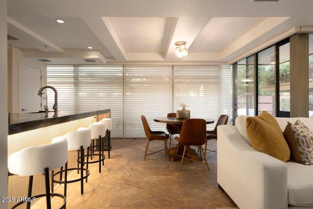 dining area with indoor wet bar and a tray ceiling