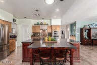818 E Hiddenview Dr, Phoenix, AZ 85048 - kitchen featuring dark countertops, freestanding refrigerator, a kitchen island, recessed lighting, and a kitchen bar